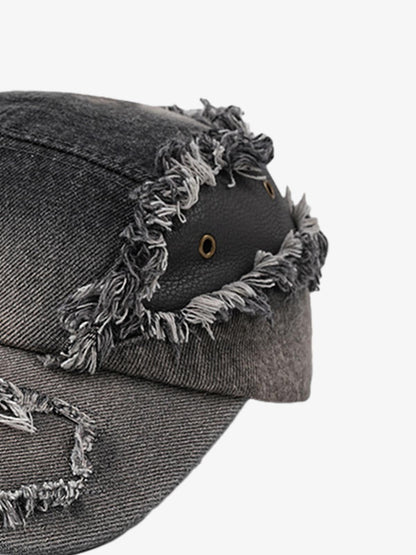 Close-up of ripped denim detailing on washed cotton cap