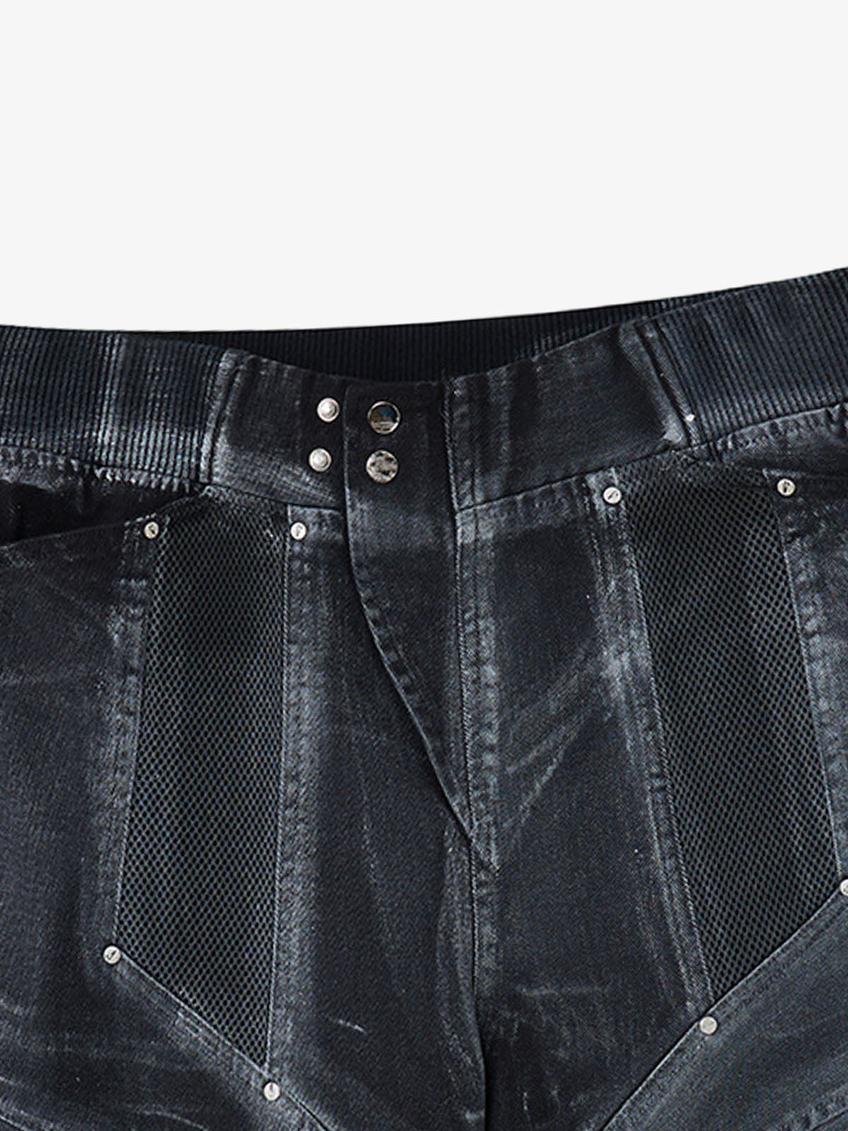 Detail of hem and fabric texture on layered denim shorts with mesh panels
