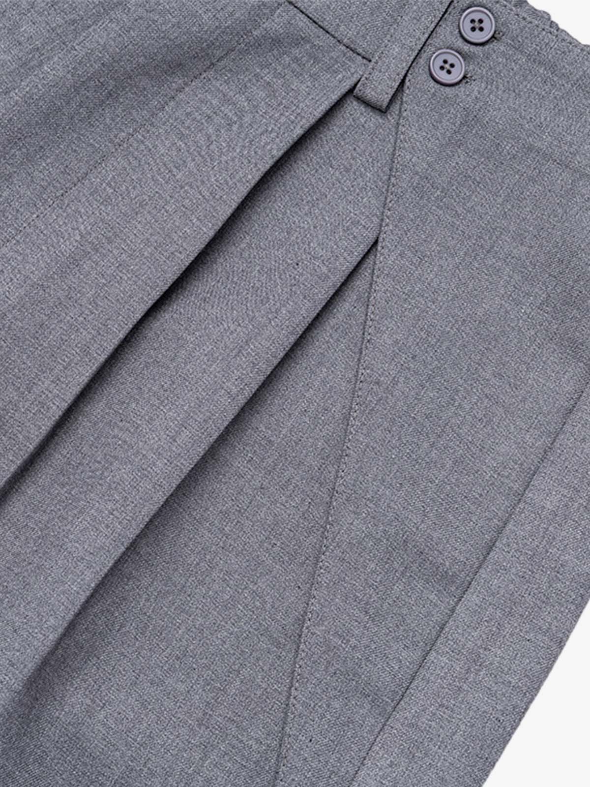 Close-up of pleated waistband detail on grey tailored shorts