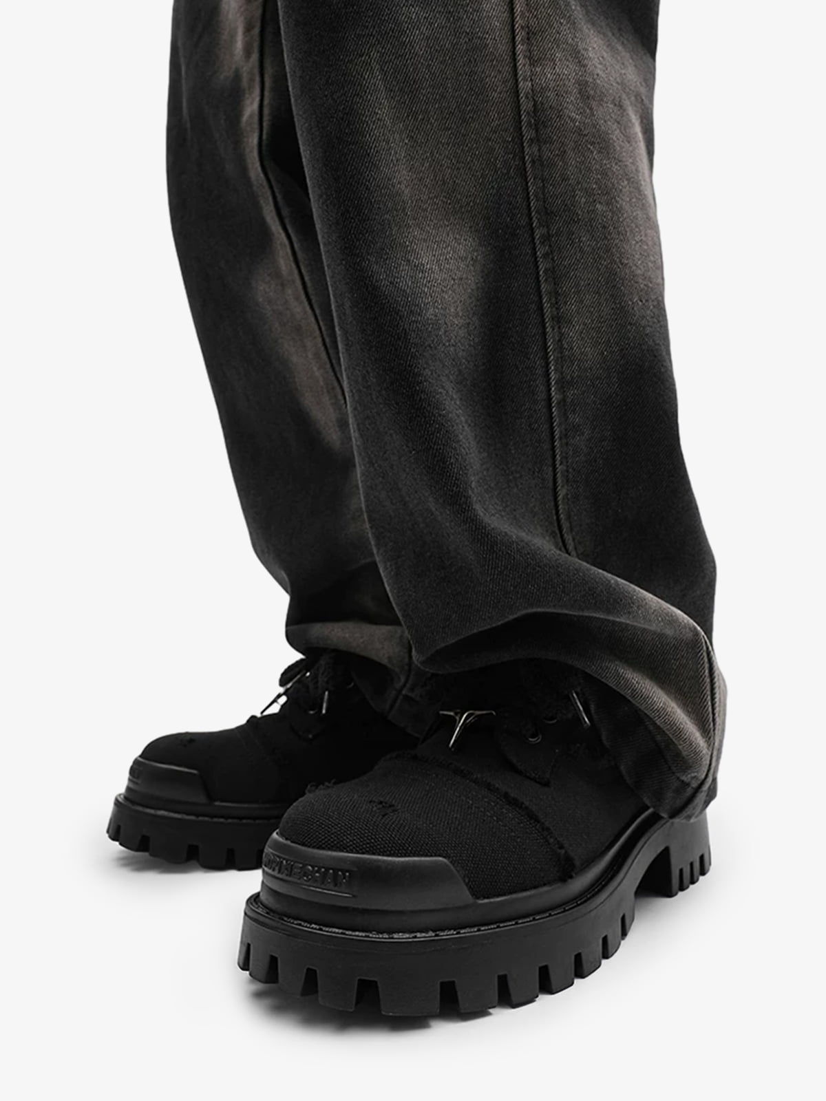 Close-up of star-shaped eyelets on black chunky platform trainers