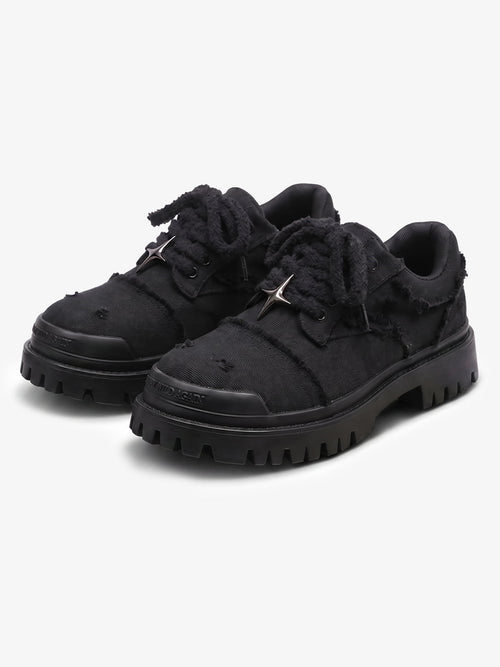 Black chunky platform trainers shown from the front with star eyelets