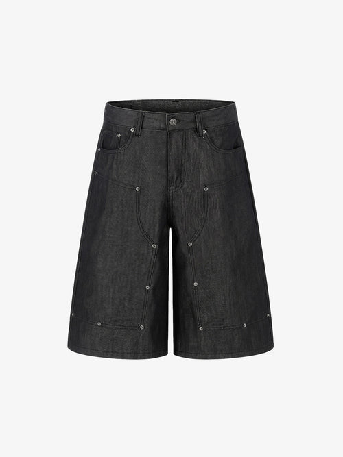 Front view of black denim shorts with stud detail and patchwork