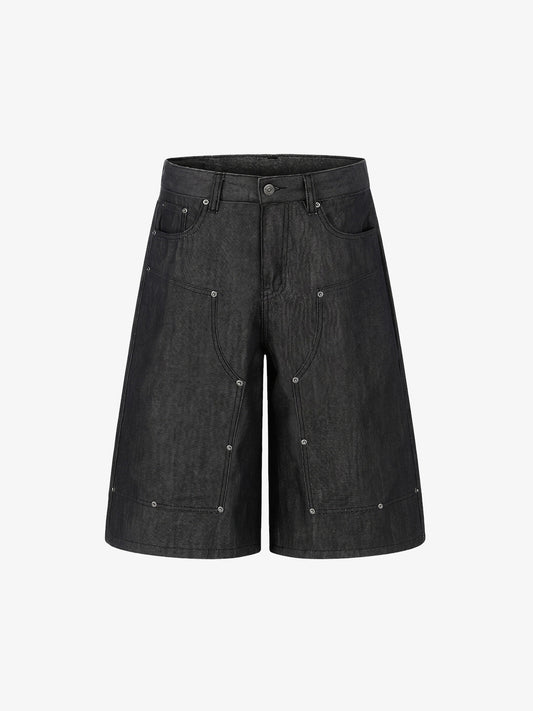Front view of black denim shorts with stud detail and patchwork