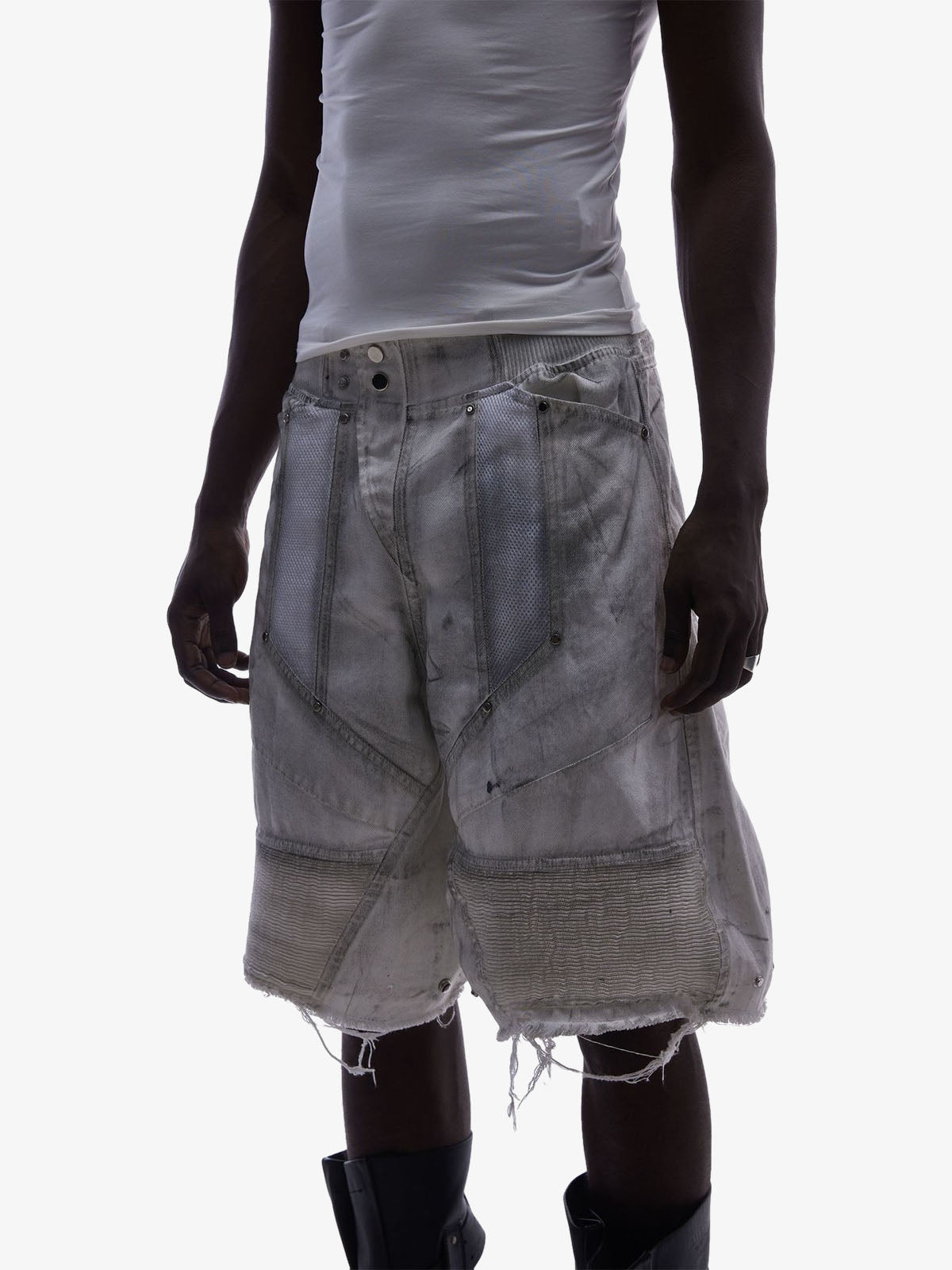 Close-up of double waist detail on layered denim shorts with mesh panels