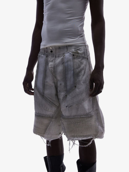 Close-up of double waist detail on layered denim shorts with mesh panels