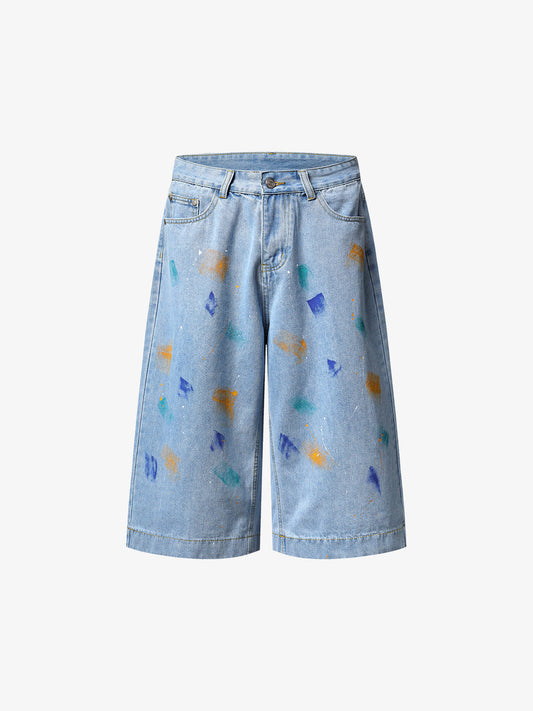 Front view of paint splatter denim wide-leg shorts in 100 cotton