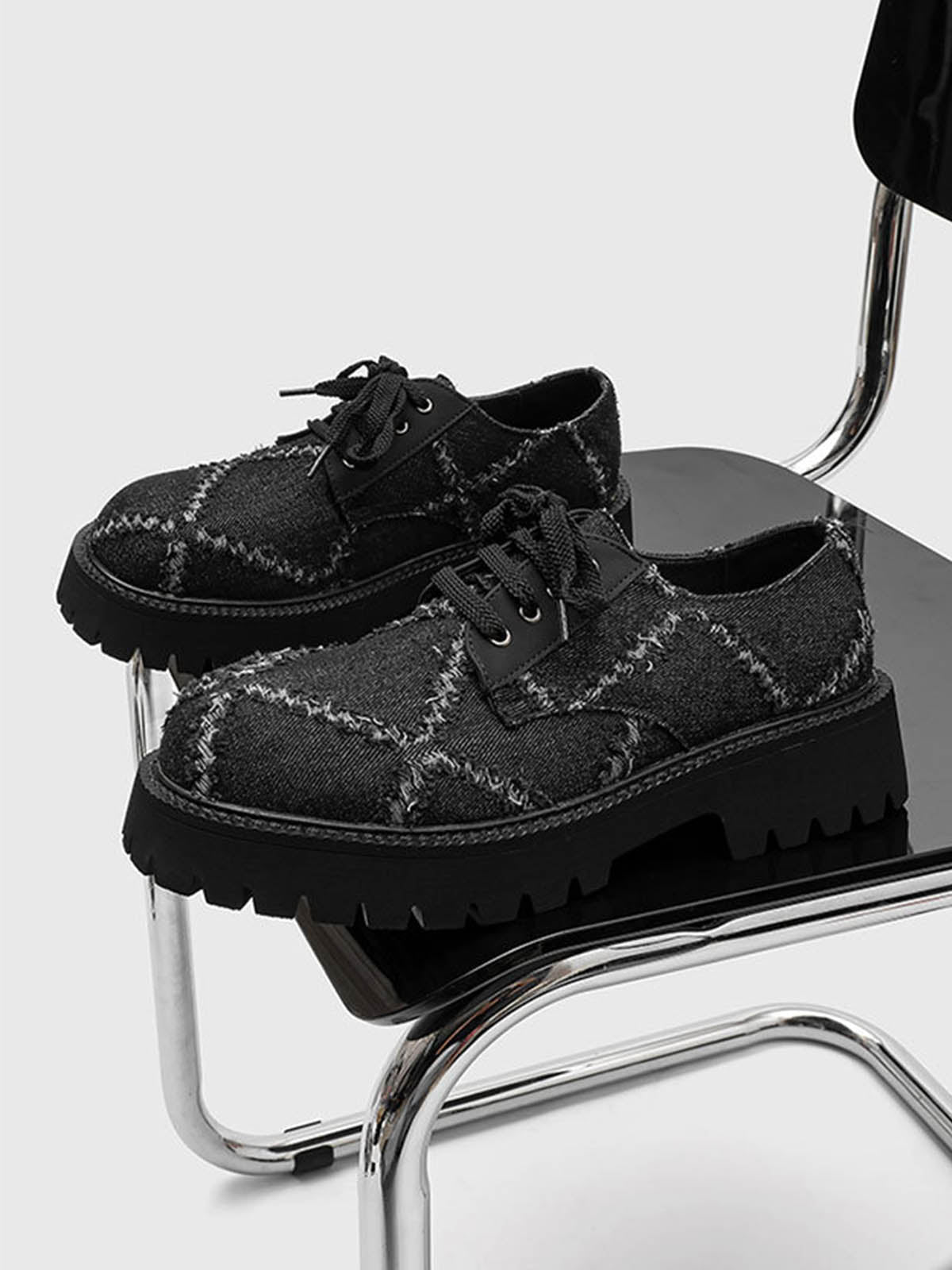 Close-up of black lace-up derby shoe with chunky platform sole