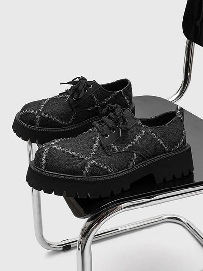 Close-up of black lace-up derby shoe with chunky platform sole