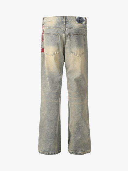 Front view of blue distressed wide-leg jeans with red embroidery