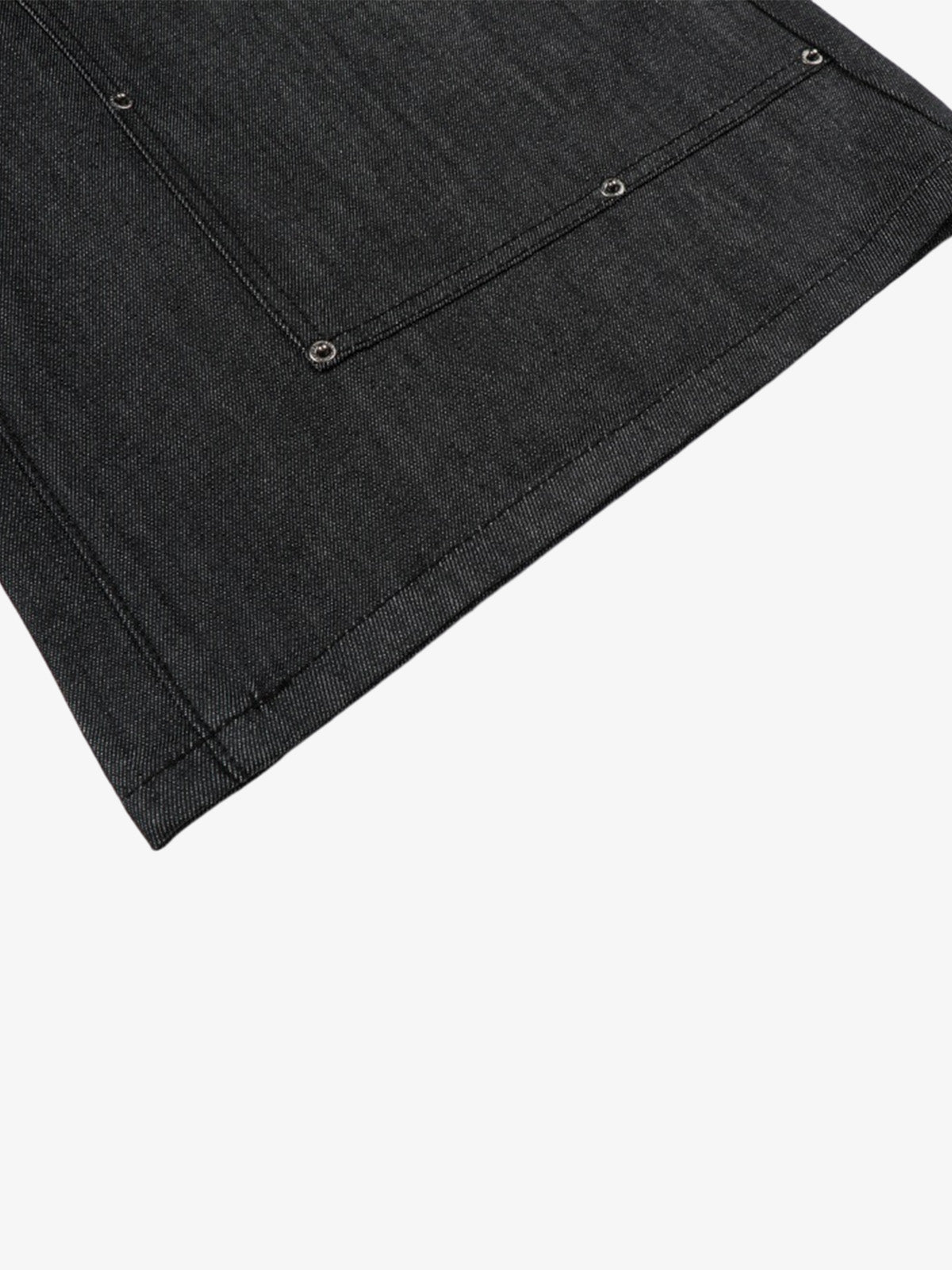 Detailed fabric view of black denim shorts with patchwork and studs