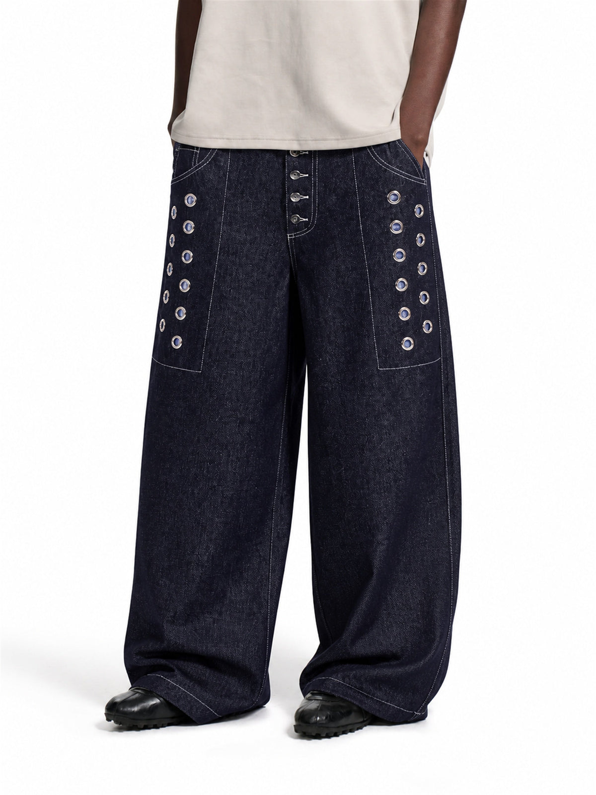 Front view of grommet baggy jeans with a button fly and relaxed fit