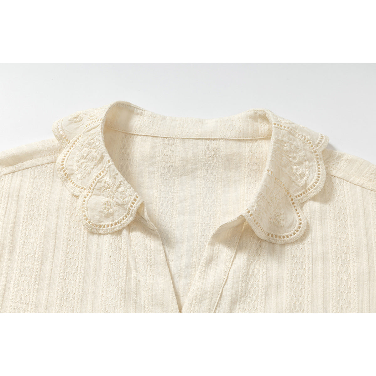 Close-up of shirt collar, buttons and shell embellishment