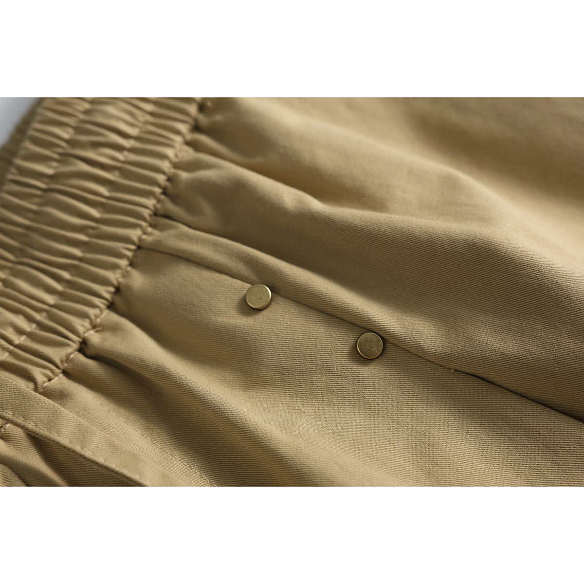 Close-up of fabric and studs on relaxed-fit shorts