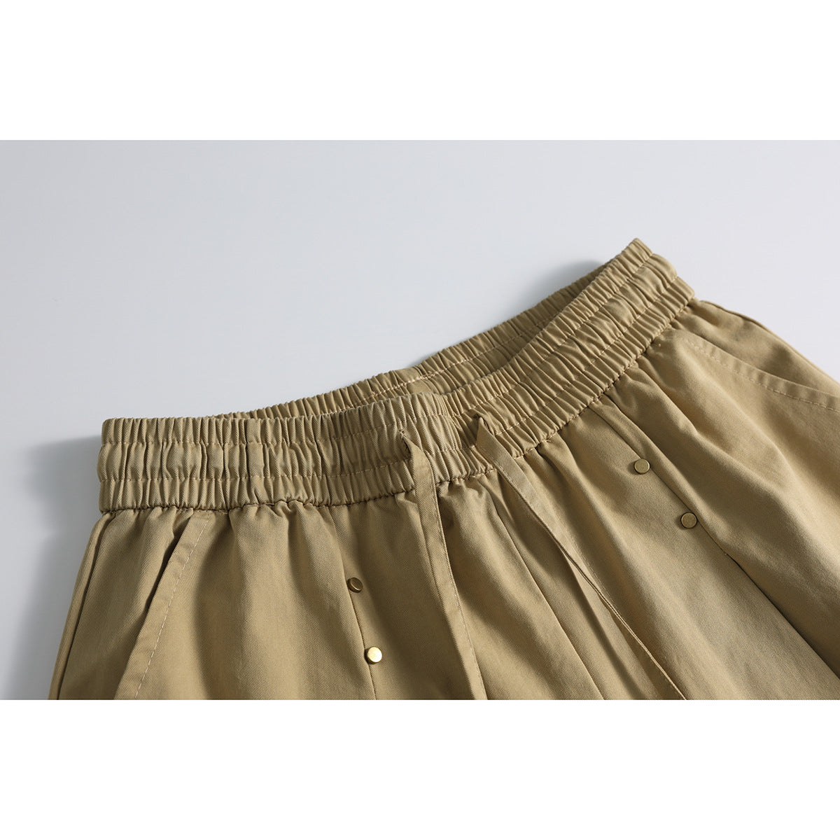 Detail of waistband and wide-leg cut on studded shorts