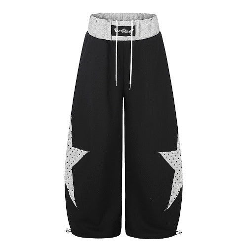 Front view of star panel baggy sweatpants with a layered waistband