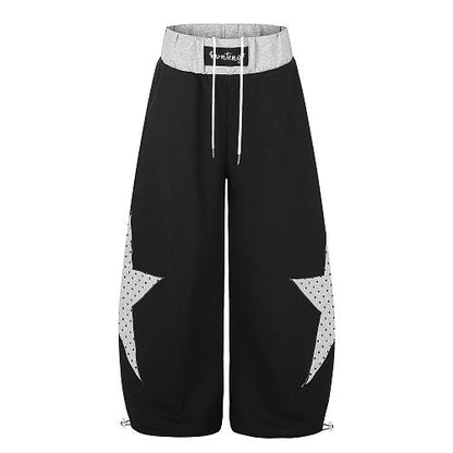 Front view of star panel baggy sweatpants with a layered waistband