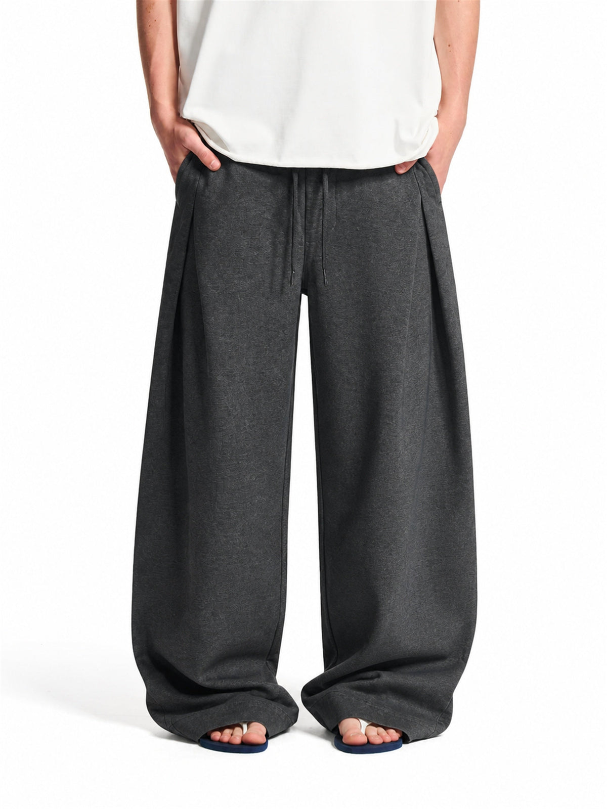 Pleated baggy sweatpants with an elastic waist shown from the front