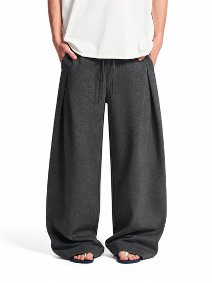 Pleated baggy sweatpants with an elastic waist shown from the front