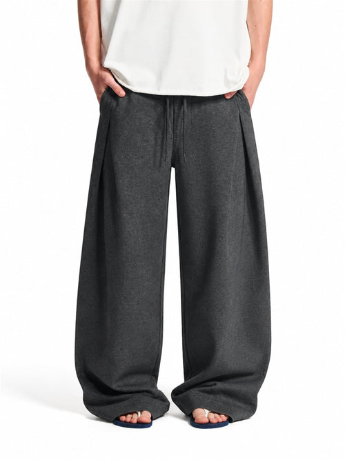 Pleated baggy sweatpants with an elastic waist shown from the front