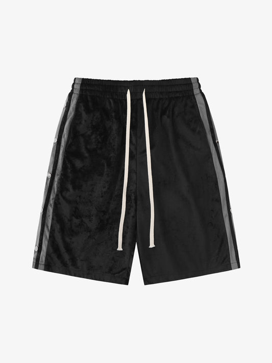 Close-up of side popper detail on suede athletic shorts