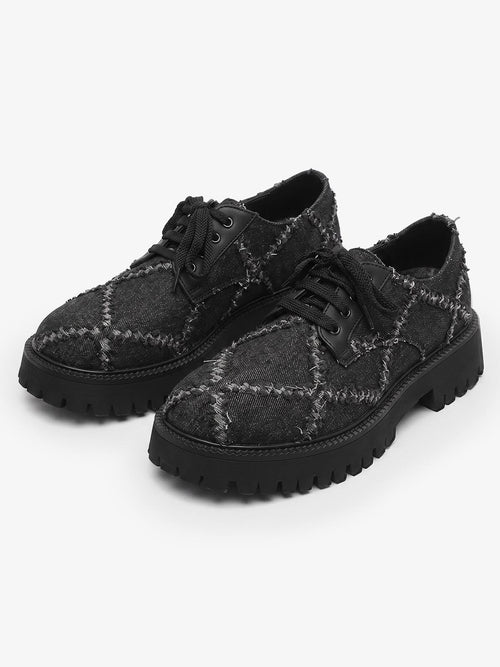 Pair of chunky black platform derby shoes with lace-up fronts