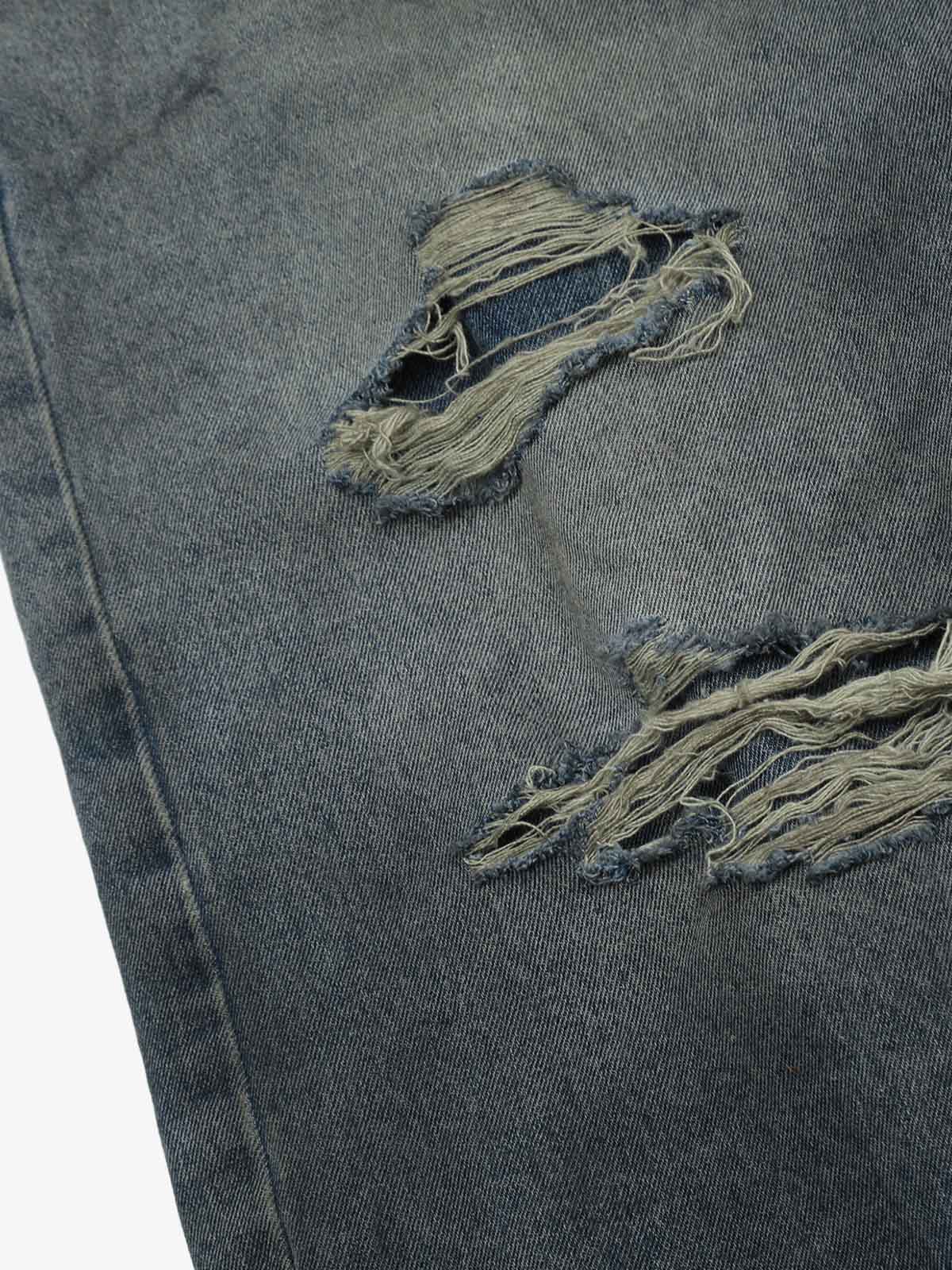 Close-up of distressed ripped detailing on the denim jeans
