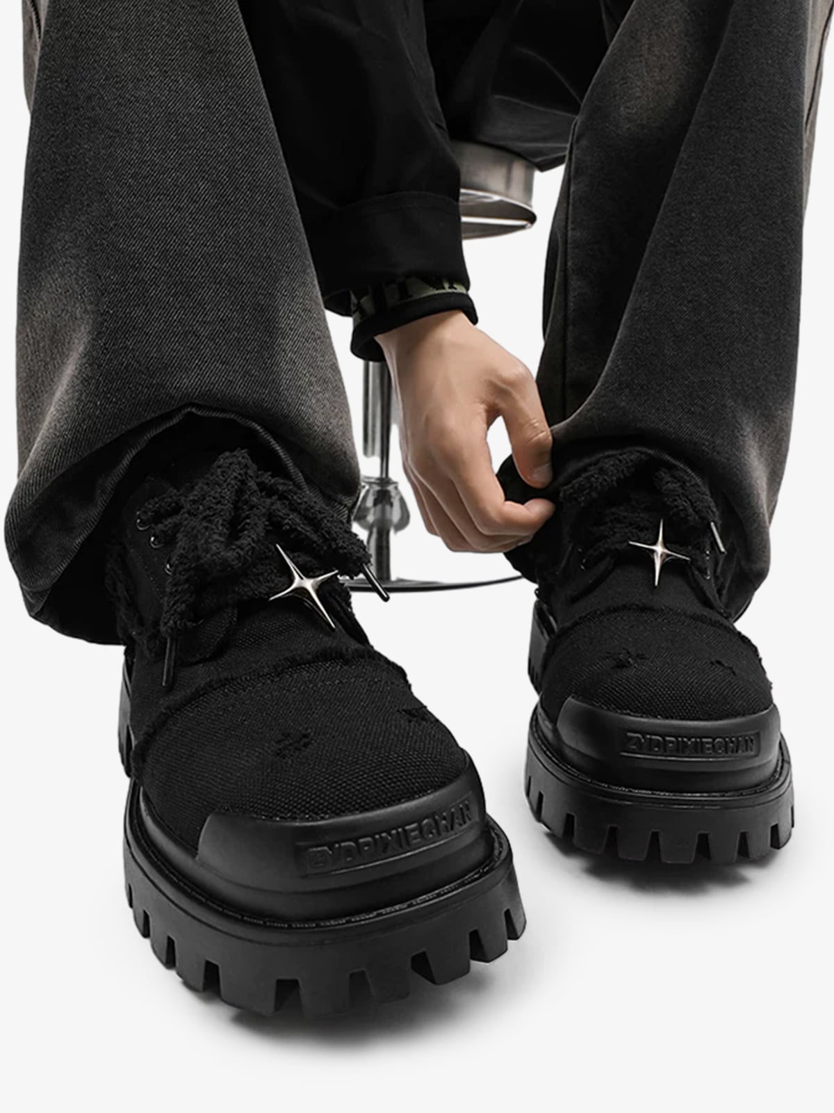 Angled view of black platform trainers displaying the star eyelets