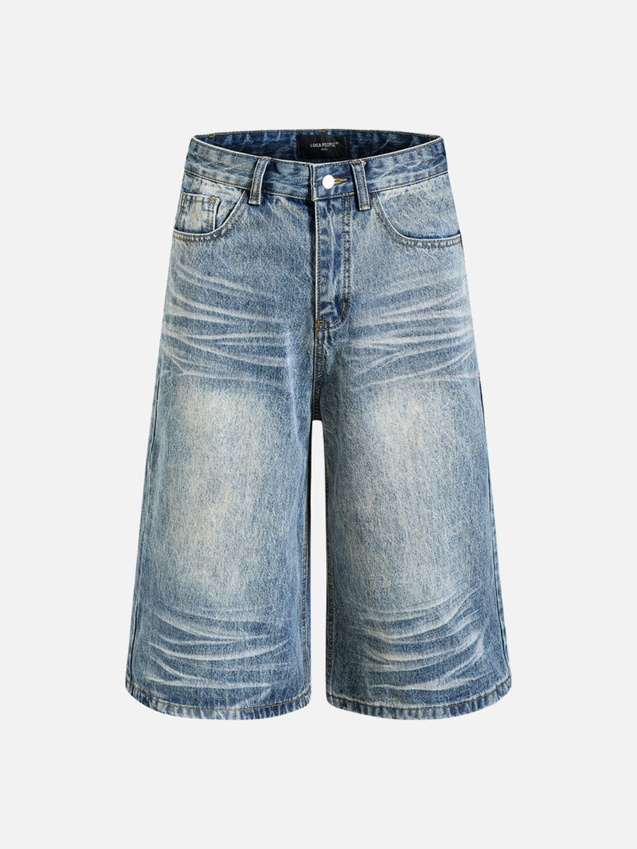Close-up of faded black denim fabric and wide-leg cut