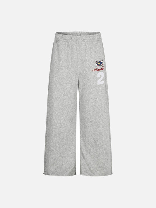 Front view of wide-leg graphic sweatpants with geometric star embroidery