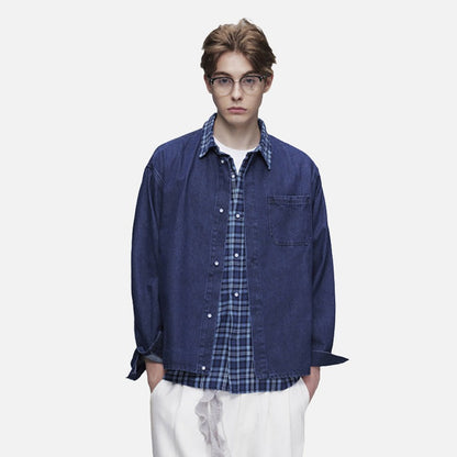 Model wearing oversized layered denim shirt in blue plaid