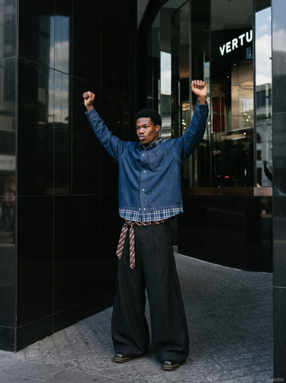Detail of layered hem and plaid fabric on oversized denim shirt