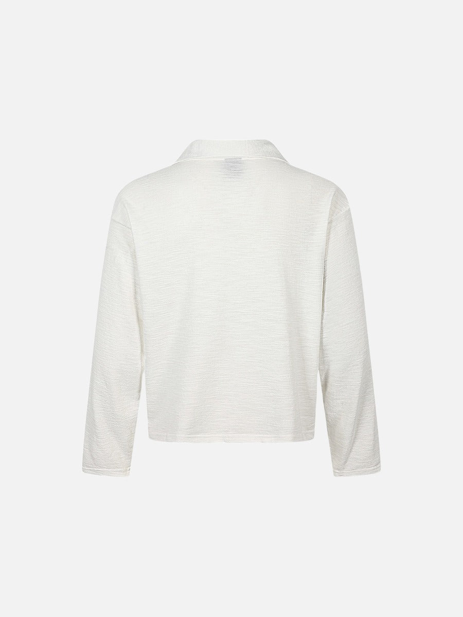 Close-up of neckline and shoulder detail on graphic knit top