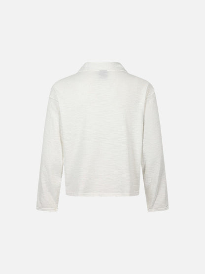 Close-up of neckline and shoulder detail on graphic knit top