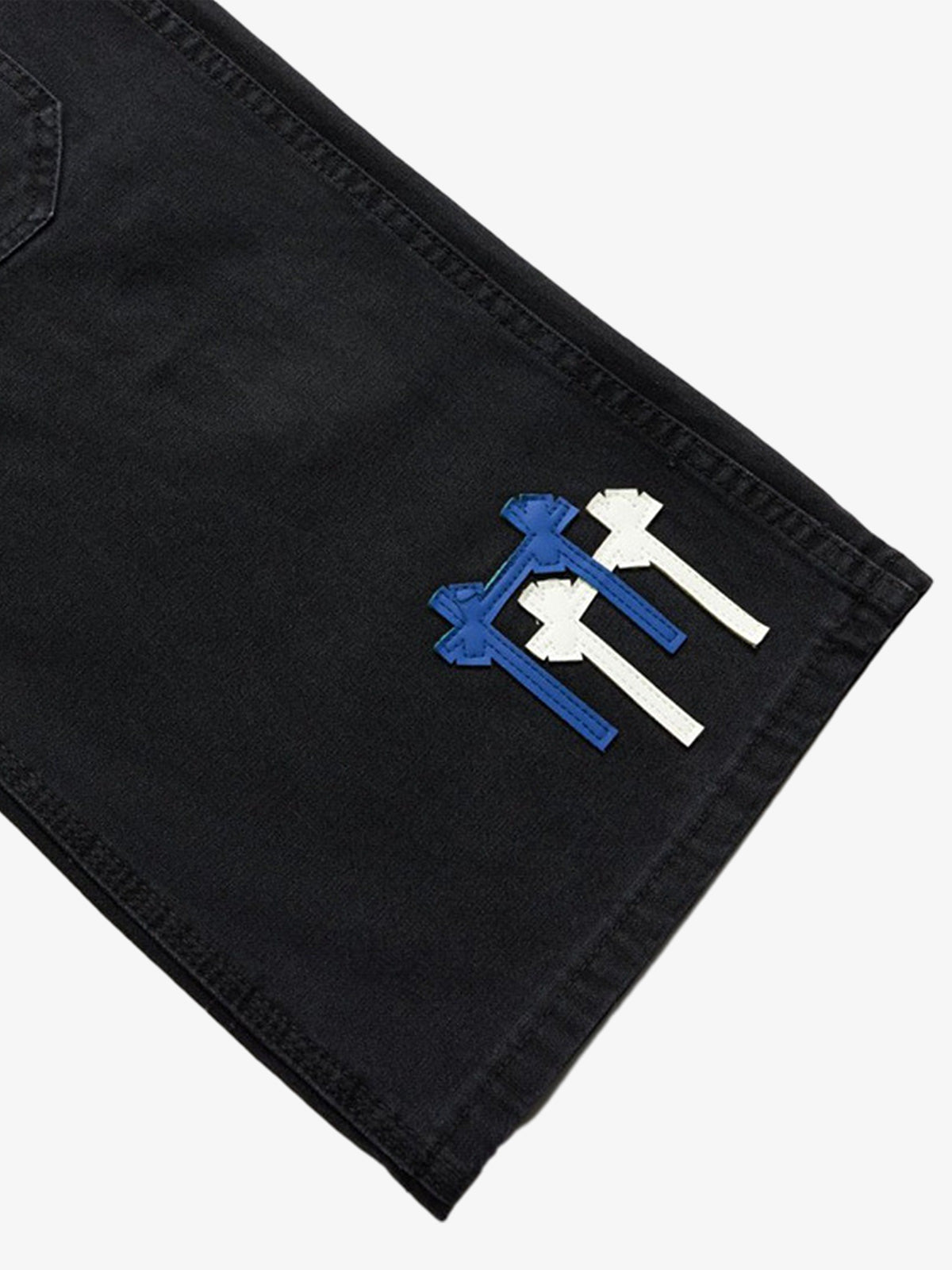 Close-up of patchwork details on heavy-duty washed denim jeans