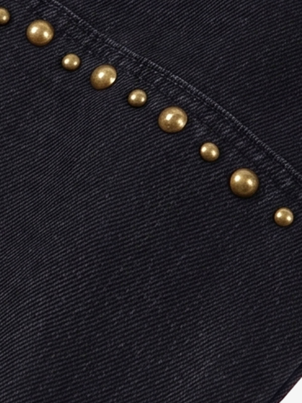 Close-up of stud detailing and distressed denim texture