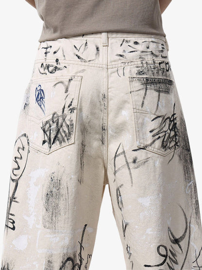 Graffiti print detailing across distressed washed denim jeans