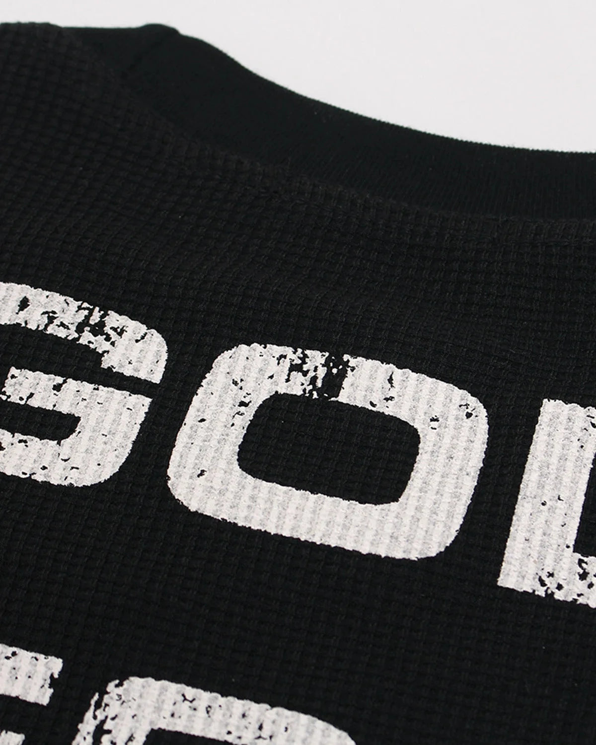 Textured waffle-knit fabric on a distressed graphic long-sleeve T-shirt